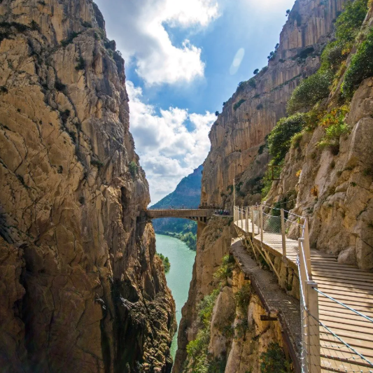 Dramatic gorge walkway on the Caminito del Rey in Andalusia, Spain, with sheer limestone cliffs and a turquoise river below