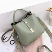 Light green women's bucket bag with gold accents.