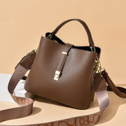 Khaki women's bucket bag with gold accents.