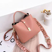 Pink women's bucket bag with gold accents.