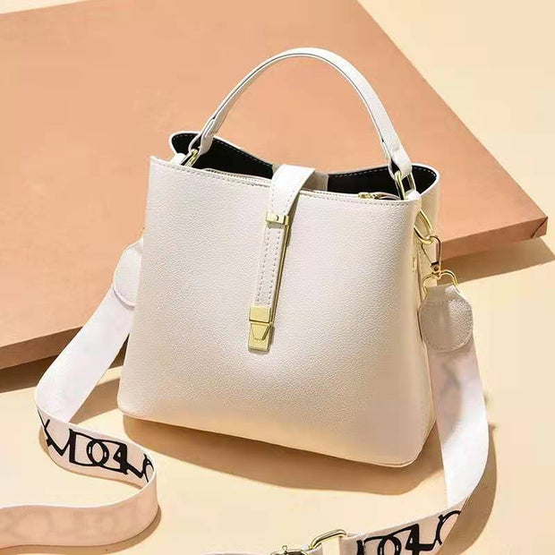 White women's bucket bag with gold accents.