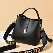 Black women's bucket bag with gold accents.