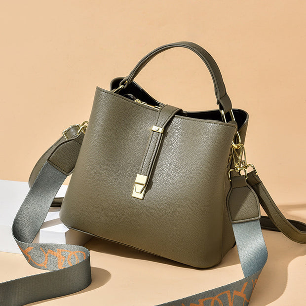 Green women's bucket bag with gold accents.