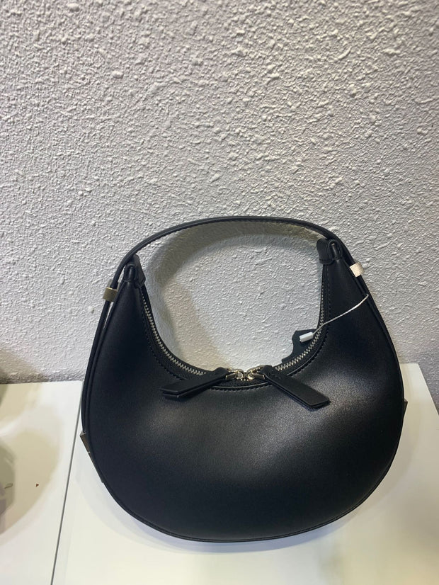 Black crescent leather small bag on table