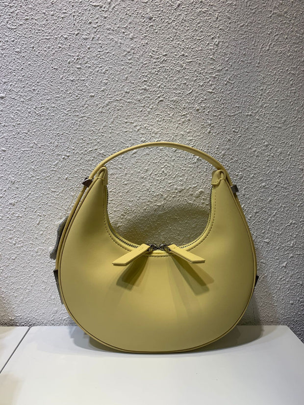 Yellow crescent leather small bag on display