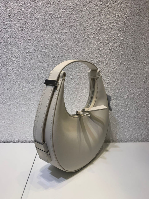 White crescent leather small bag on display