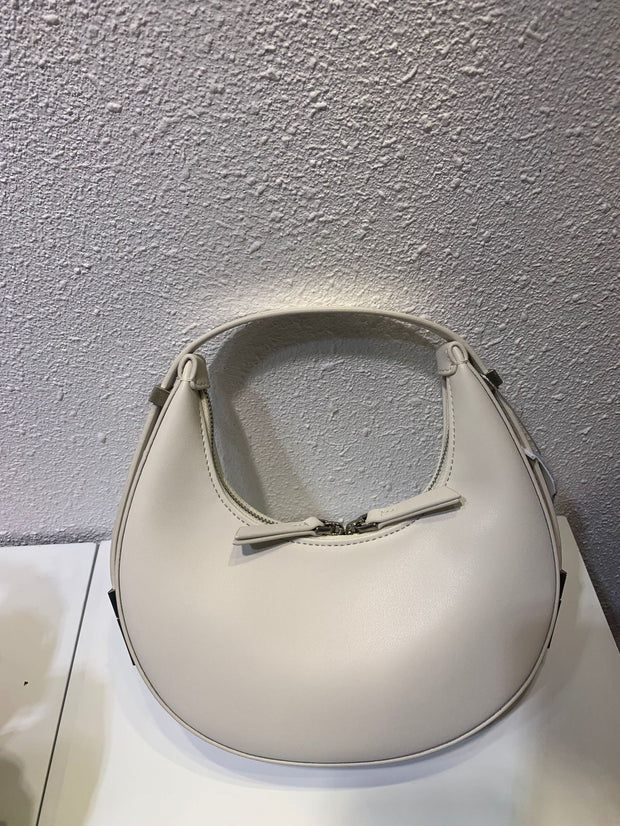 White crescent leather small bag on white surface