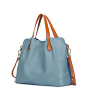 Side view of blue leather tote bag with brown strap