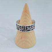 Zodiac ring displayed on wooden cone stand