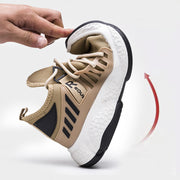 Flexible beige mesh sports shoe demonstrating bendability.