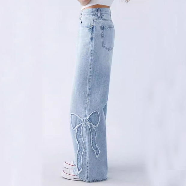 Side view of light blue embroidered jeans with bow design