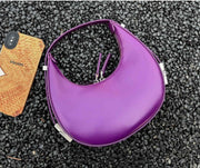 Purple crescent leather small bag on textured surface