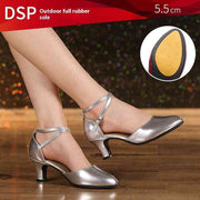 Silver dance shoes with 5.5 cm heel on wooden floor