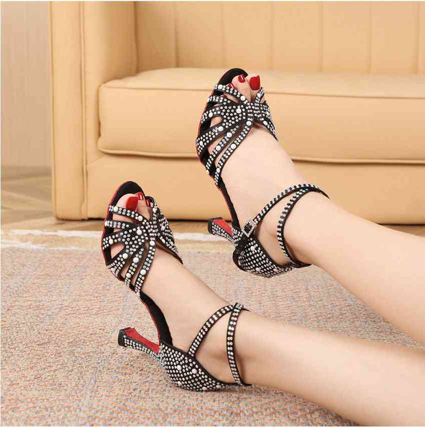 Black rhinestone Latin dance shoes worn on feet