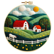 Wool felt painting of countryside with houses and animals