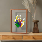 DIY handprint frame with colorful prints on wooden table