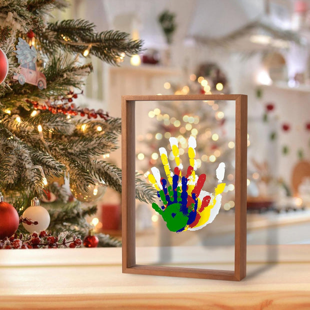 Festive DIY handprint frame near Christmas tree