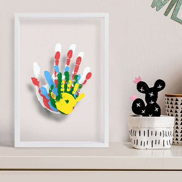 DIY handprint frame with colorful prints on shelf