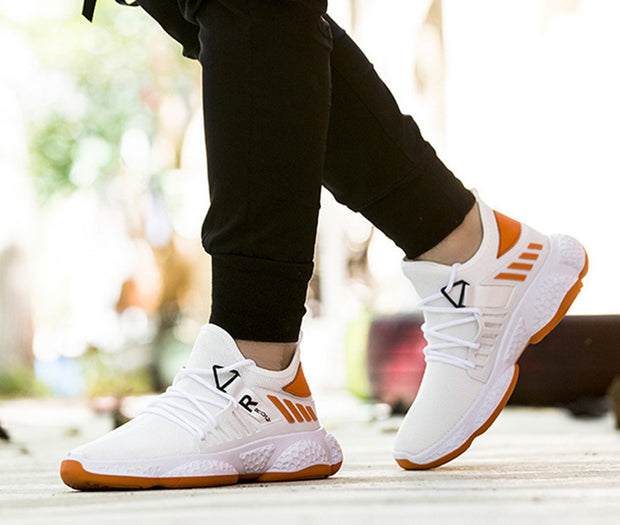 White mesh sports shoes with orange accents in use.