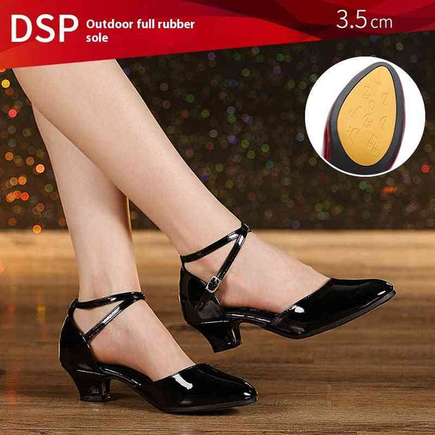 Black dance shoes with 3.5 cm heel on wooden floor