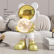 Gold astronaut bear with moon lamp on sofa