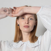 Model wearing black triangle leather earrings