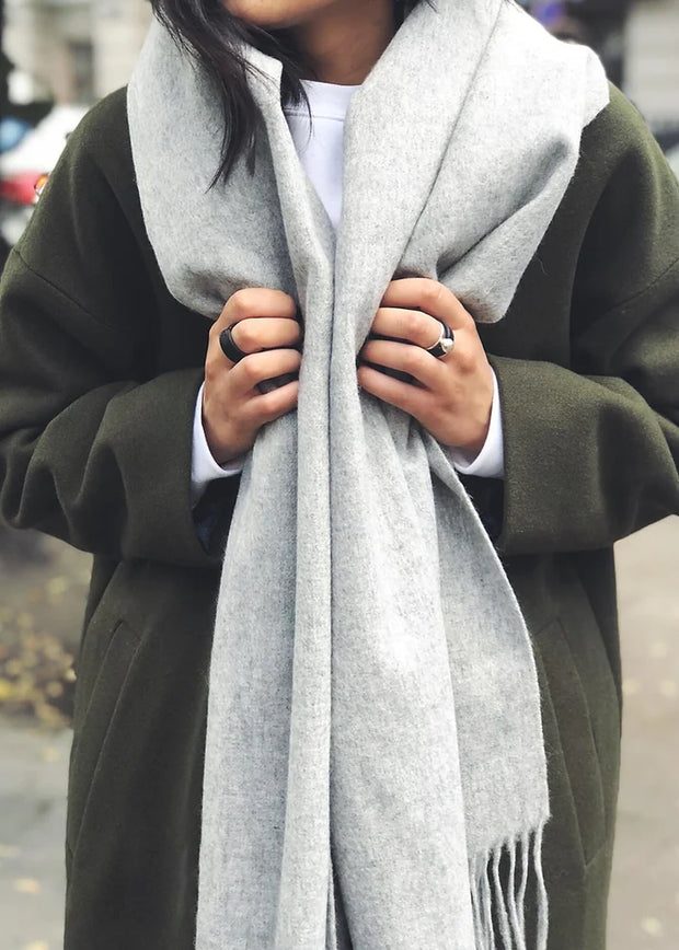 Person with scarf wearing leather band rings