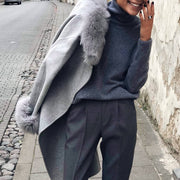 Woman in gray outfit wearing leather ring with silver detail