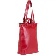 Side view of red structured leather tote bag showcasing sleek design, adjustable strap, and durable craftsmanship for versatile use.