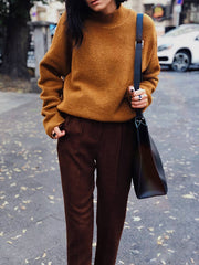 Woman in brown outfit wearing leather ring with silver detail