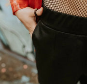 Person wearing leather ring with bronze tone circle detail