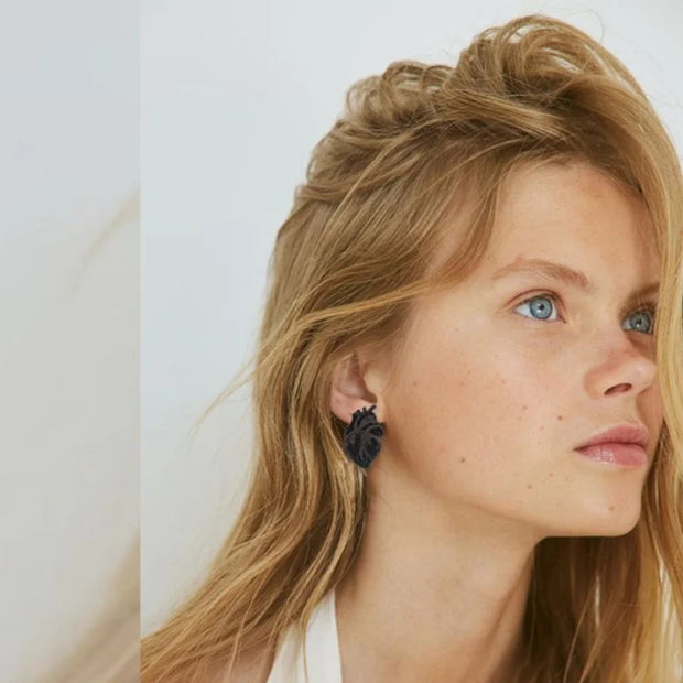 Model wearing black heart shape leather earrings